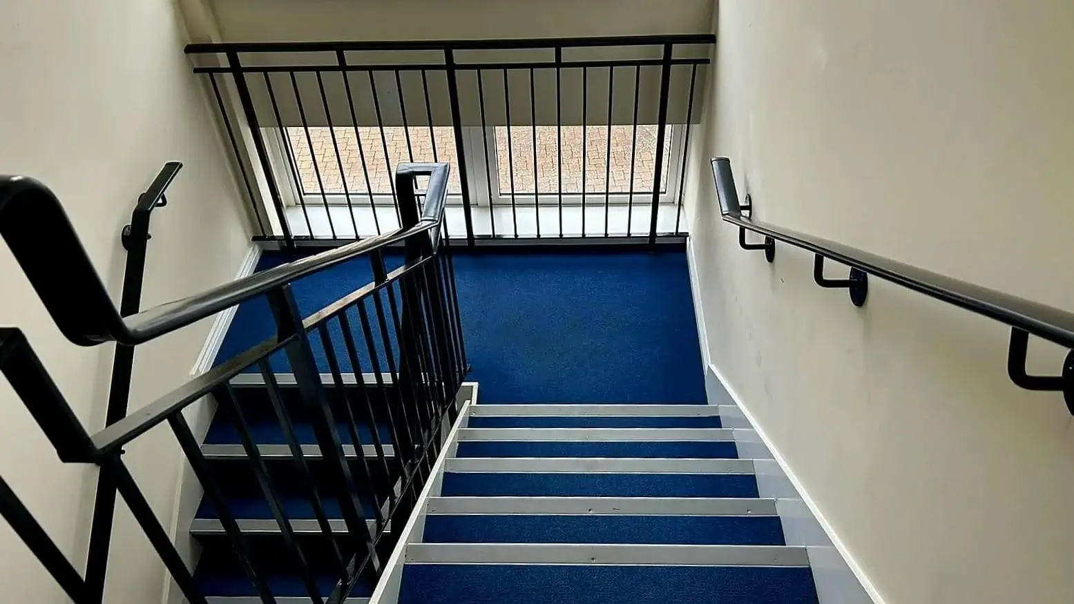 A clean stairwell in a residential block showing the importance of regular communal area cleaning for tenant satisfaction.