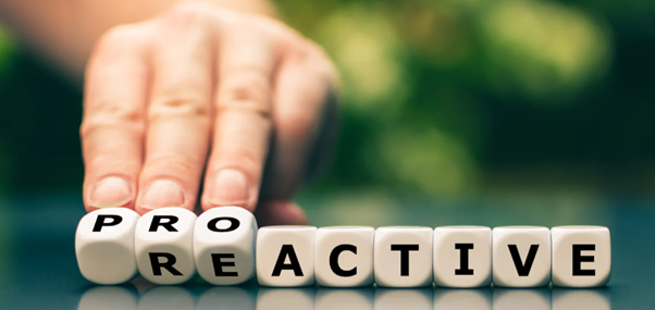 Someone flipping some dice over to reveal the word proactive instead of reactive, showing the importance of proactive pest control services for businesses.