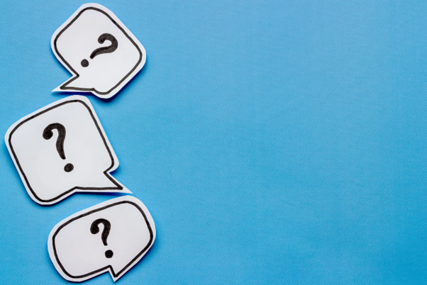 Question marks on a blue background depicting people asking the question of the difference between a janitor and caretaker in school maintenance.