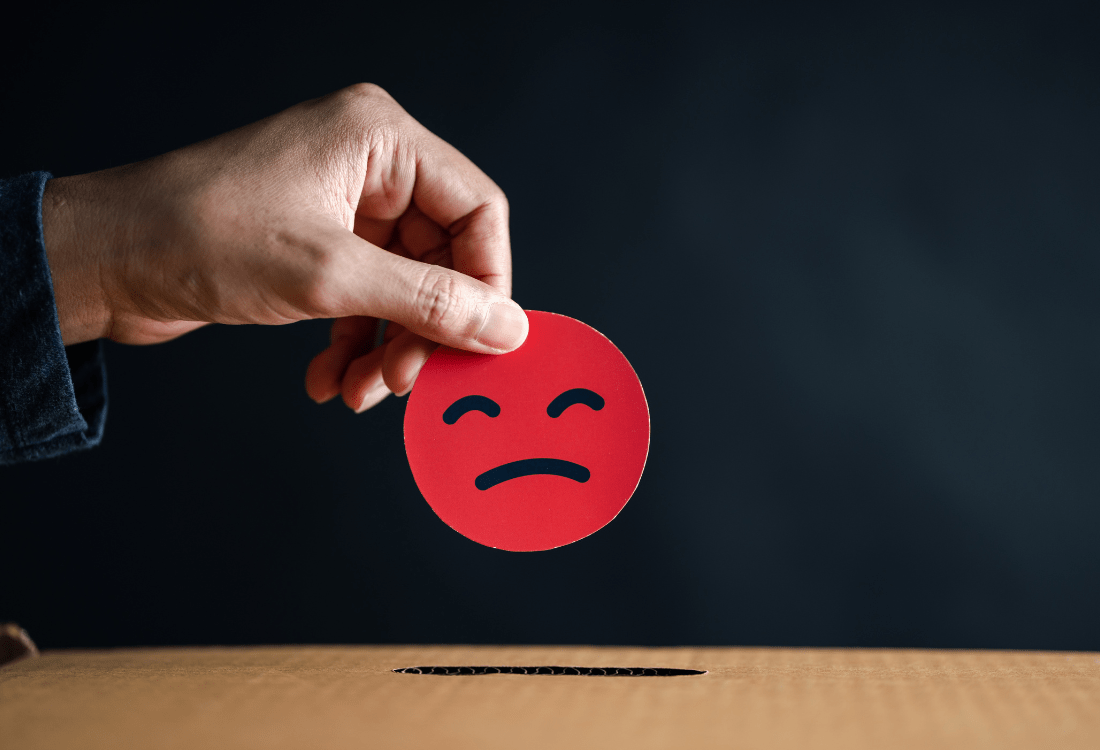 A man putting a negative token in a box to show his disdain for the service he has experienced after choosing a cheap office cleaning provider.